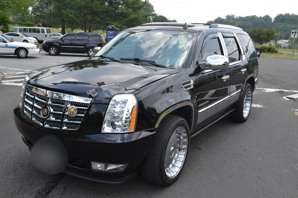 Photograph of front of SUV showing damage to hood.